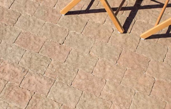 A close up of limestone paver installed, with wooden chairs