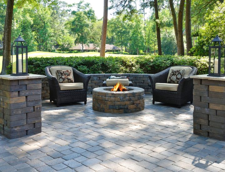 Paver patio made of cobblestones, a firepit, and two outdoor chairs